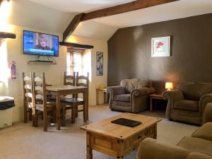 a living room with a couch and a table and a tv at Porth Cottage- W40885 in Perranporth