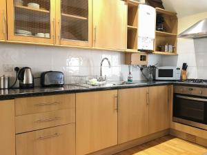 a kitchen with wooden cabinets and a sink at Porth Cottage- W40885 in Perranporth