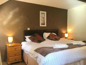 a bedroom with a bed and two night stands with lamps at Porth Cottage- W40885 in Perranporth +17 photos