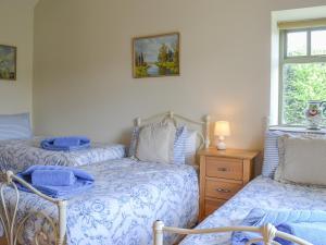 a bedroom with two beds and a window at Stables Cottage-W42586 in Burn +10 photos