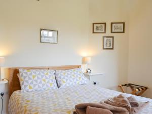 a bedroom with a bed and three pictures on the wall at Stables Cottage-W42586 in Burn