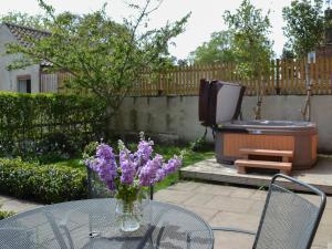 a vase of purple flowers sitting on a glass table at The Forge-W42942 in Burn +10 photos