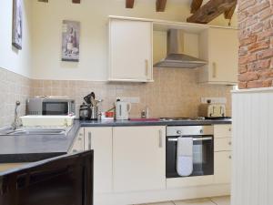 a kitchen with white cabinets and a stove top oven at The Forge-W42942 in Burn