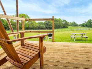a wooden bench sitting on a wooden deck with a picnic table at Swallow - Safari Tent - Ukc8985 in Romsey