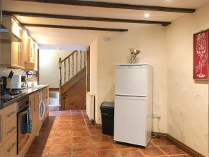 a kitchen with a white refrigerator in a room at Crantock Cottage- W40888 in Perranporth