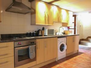a kitchen with a stove and a washing machine at Crantock Cottage- W40888 in Perranporth