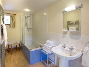 a bathroom with a sink and a shower and a tub at Ty Cerbyd in Cilybebyll