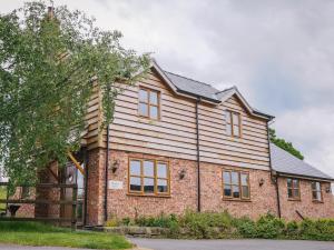 a brick house with a gambrel roof at Drovers Barn in Malpas