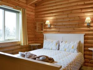 a bedroom with a bed in a log cabin at Mallard Lodge - W43171 in Burn
