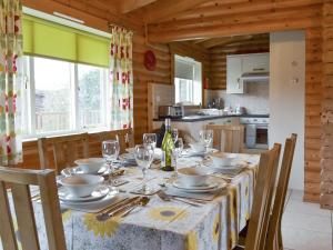 a dining room with a table with plates and wine glasses at Mallard Lodge - W43171 in Burn