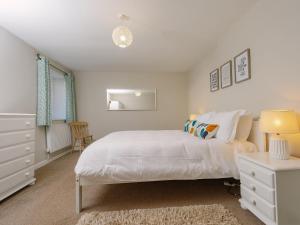 a white bedroom with a white bed and a chair at Number Four - Ukc4966 in Tawstock