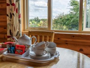 a table with a tray with tea pots and cups on it at Partridge Lodge-W43008 in Burn