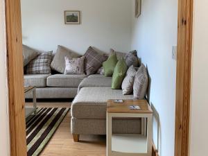 a living room with a couch and a table at Ploughmans Cottage-Uk7346 in Dyke