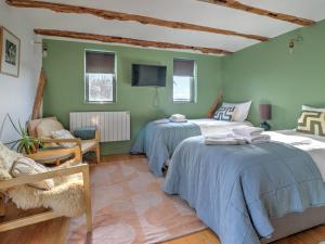 a bedroom with two beds and a tv on the wall at Staddlestone Barn - Ukc8984 in Romsey