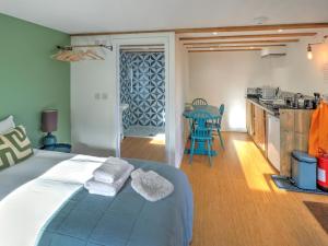 a bedroom with a bed and a kitchen with a table at Staddlestone Barn - Ukc8984 in Romsey