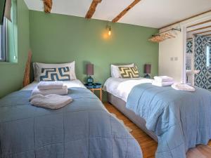 two beds in a room with green walls at Staddlestone Barn - Ukc8984 in Romsey