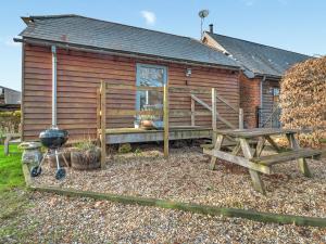 a log cabin with a grill and a picnic table at Staddlestone Barn - Ukc8984 in Romsey +2 photos