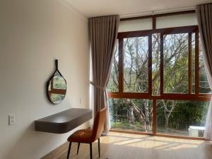 a room with a window and a bench and a chair at BM homestay in Buôn Dhă Prŏng