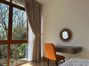 a bedroom with a window with a chair and a mirror at BM homestay in Buôn Dhă Prŏng
