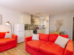 a living room with a red couch and a kitchen at Number Five - Ukc4967 in Tawstock