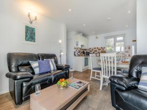 a living room with two leather couches and a table at 10 Mount Brioni in Downderry