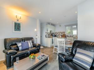 a living room with a leather couch and a table at 10 Mount Brioni in Downderry +13 photos