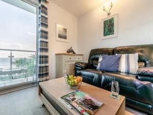 a living room with a leather couch and a table at 10 Mount Brioni in Downderry