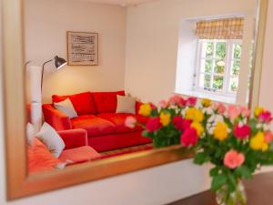 a living room with a red couch and a mirror at Number Five - Ukc4967 in Tawstock