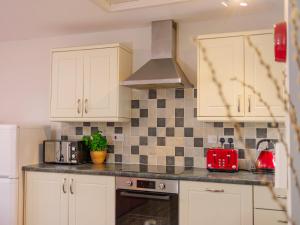 a kitchen with white cabinets and black and white tiles at Number Five - Ukc4967 in Tawstock +22 photos