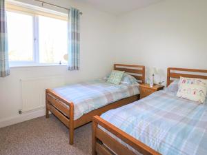 a bedroom with two beds and a window at Tennyson Cottage in Freshwater +6 photos