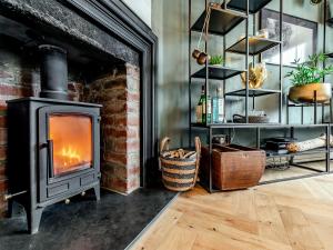 a fireplace in a living room with a stove at 17 Mount Brioni in Downderry