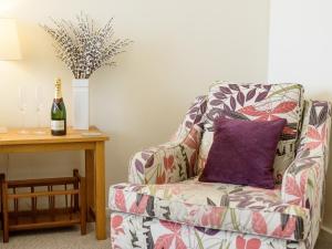 a chair with a purple pillow and a bottle of wine at Langetot in Bury Saint Edmunds