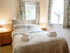 a bedroom with a bed with towels on it at Langetot in Bury Saint Edmunds