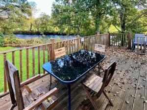 a table and chairs on a deck with a fence at The Ardle in Crieff