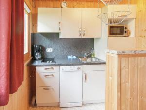 małą kuchnię z białymi szafkami i zlewem w obiekcie Holiday home with private terrace in Gehren w mieście Altenfeld