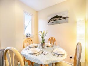 a dining room with a white table and chairs at 11 Mount Brioni - Ukc5345 in Torpoint +9 photos