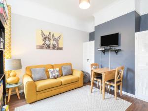 a living room with a couch and a table at Kenmare Cottage in Shanklin