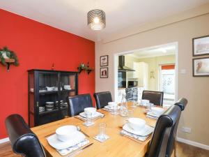 a dining room with a wooden table and black chairs at Kenmare Cottage in Shanklin +17 photos
