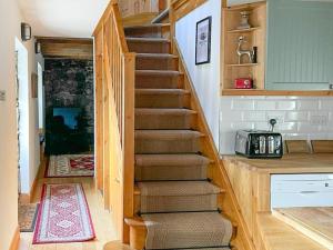 a stairway in a home with a stone wall at Culrain Cottage in Fort Augustus