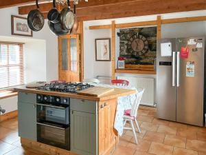 a kitchen with a stove and a refrigerator at Culrain Cottage in Fort Augustus