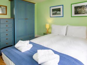 a bedroom with a bed with towels on it at 1 Bell Lodge in Thorpeness +7 photos