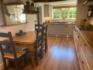 a kitchen with a wooden table and a wooden floor at Victory Cottage in Cottesmore