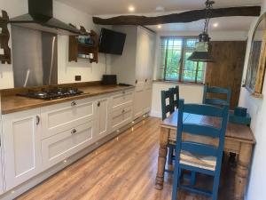 a kitchen with a wooden table and blue chairs at Victory Cottage in Cottesmore +10 photos