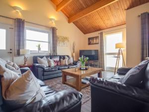 a living room with leather couches and a table at Eagle 3 Star - Ukc5056 in Aviemore