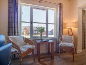 a living room with a window and two chairs and a table at Eagle 3 Star - Ukc5056 in Aviemore +20 photos