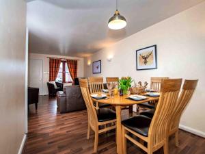 a dining room and living room with a table and chairs at The Osprey-Ukc5062 in Aviemore