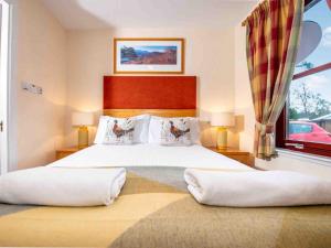 a bedroom with a large bed and a window at The Osprey-Ukc5062 in Aviemore +4 photos