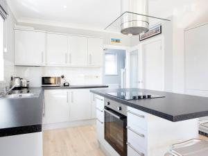 a kitchen with white cabinets and a black counter top at Northwood 2 in Broadstairs