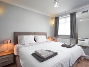a bedroom with a large white bed with towels on it at Northwood 2 in Broadstairs