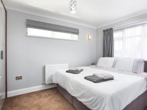 a bedroom with a bed with white sheets and a window at Northwood 2 in Broadstairs